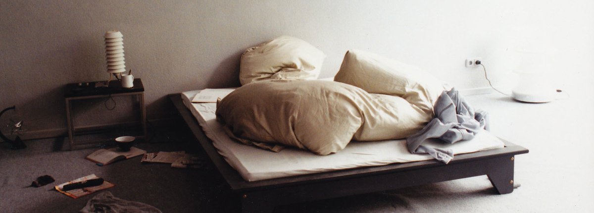Ein lichtdurchflutetes Designer Loft mit Futonbett und hellgrauen Wänden und Teppichboden